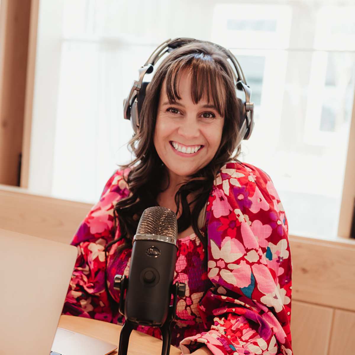 How to find your why. Woman sitting in front of computer with headphones, talking into mic